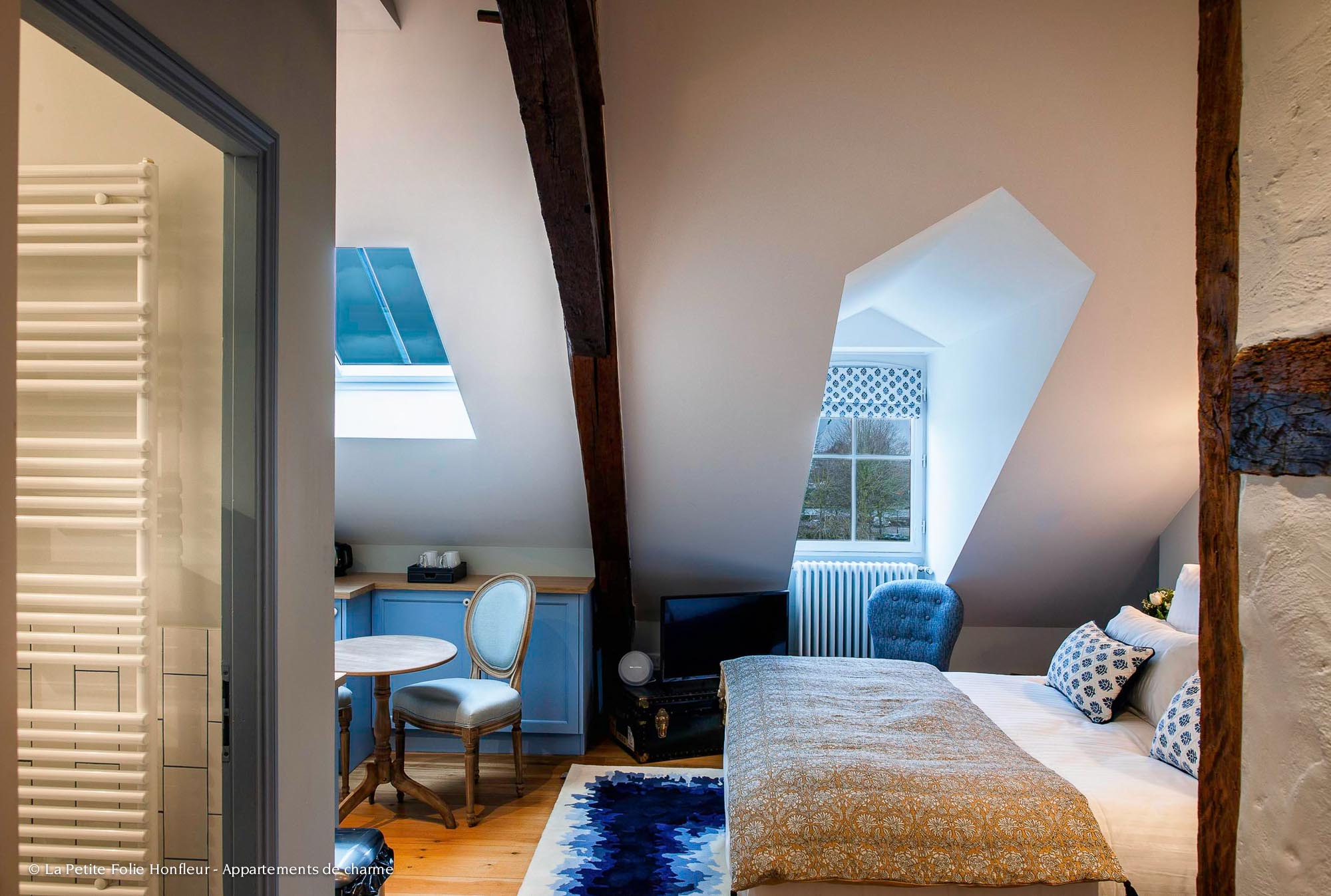 Vue sur l'appartement Erik Satie, avec lit et coin cuisine. Idéal pour une nuit romantique en Normandie.